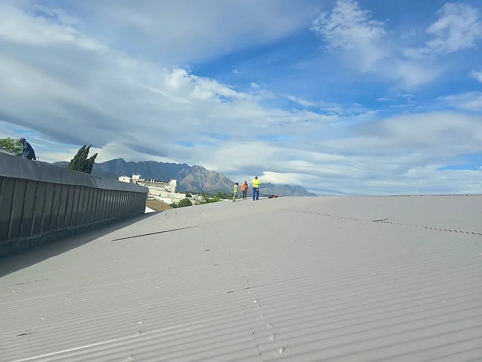 Roof Direct team in high-visibility vests on a large commercial roof in Worcester after it was painted